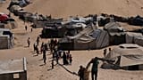 نازحون فلسطينيون يسيرون عبر مخيم خيام في مواصي خان يونس، وهي منطقة صنفتها إسرائيل كمنطقة آمنة، في خان يونس جنوب قطاع غزة، الأحد 21 سبتمبر 2025