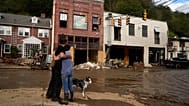 Resident Anne Schneider, right, hugs her friend, Eddy Sampson, as they survey damage caused by Hurricane Helene on Oct. 1, 2024.