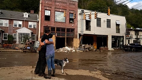 Resident Anne Schneider, right, hugs her friend, Eddy Sampson, as they survey damage caused by Hurricane Helene on Oct. 1, 2024.