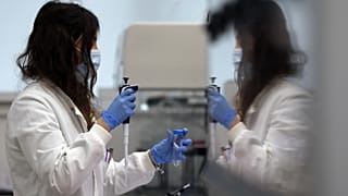 مساعدة مختبر تستخدم الماصّة لتحضير RNA لفيروس كورونا من أجل التسلسل الجيني في معهد ويلكوم سانجر الذي تديره أبحاث الجينوم في كامبريدج