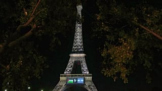 Um ecrã de grandes dimensões mostra as bandeiras da Palestina e de Israel e uma pomba na Torre Eiffel, domingo, 21 de setembro de 2025, em Paris.