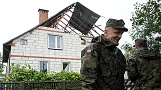 FILE: Territorial defence officers stand near a damaged house, after Russian drones violated Polish airspace during an attack on Ukraine, in Wyryki, Poland, 11 Sept 2025. 