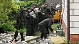 Agenti della difesa territoriale ripuliscono i detriti dal tetto distrutto di una casa, dopo l'attacco di più droni russi, a Wyryki, vicino a Lublino, in Polonia, giovedì 11 settembre 2025.