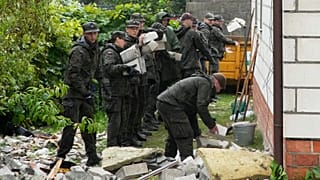 Agenti della difesa territoriale ripuliscono i detriti dal tetto distrutto di una casa, dopo l'attacco di più droni russi, a Wyryki, vicino a Lublino, in Polonia, giovedì 11 settembre 2025.