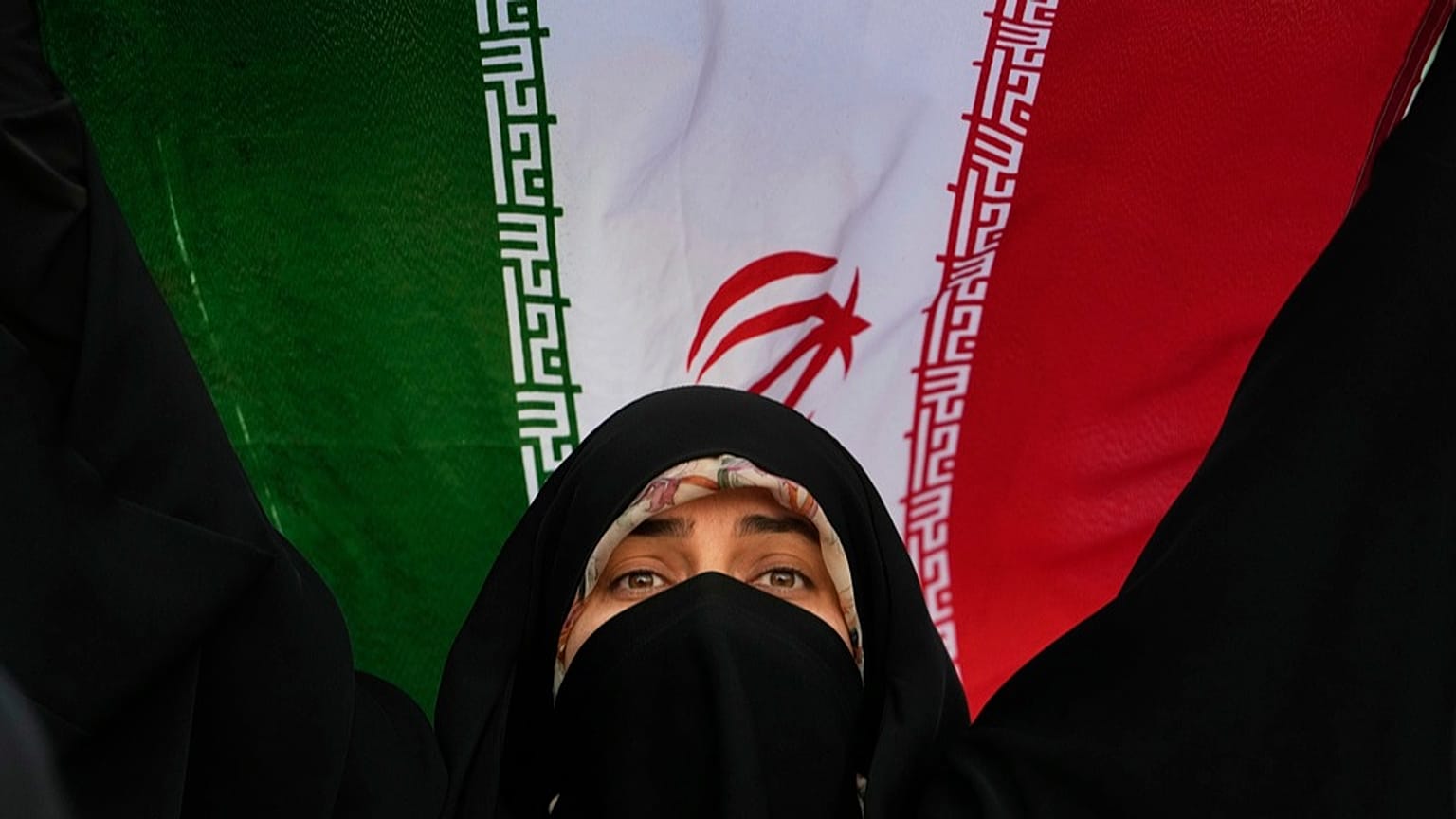 امرأة إيرانية ترفع ��لم بلادها، 24 يونيو 2025.