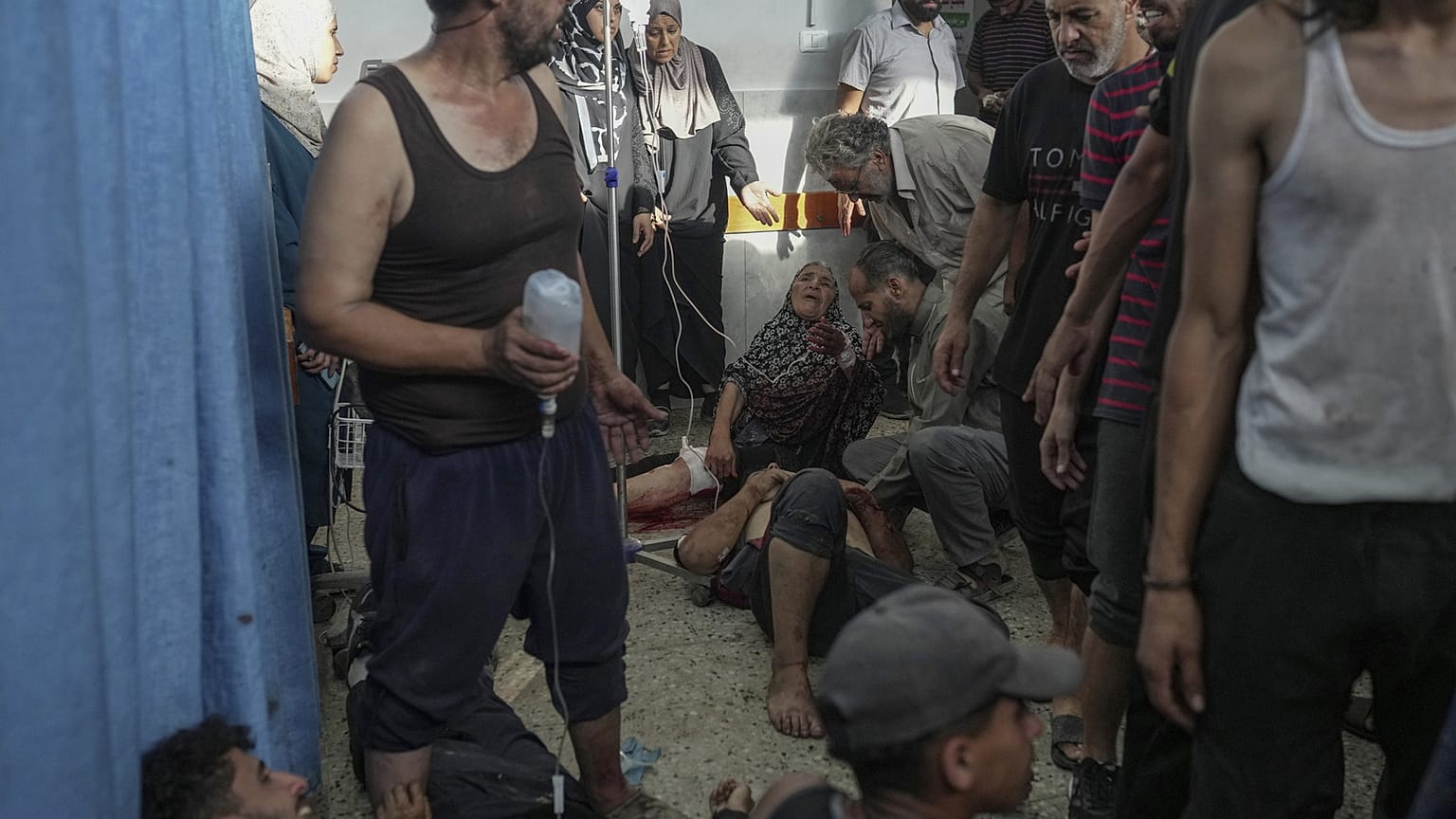 فلسطينيون جرحى يتلقون العلاج على الأرض في مستشفى الشفاء بمدينة غزة
