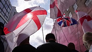 FILE: Demonstrators carry England and Union Jack flags during a Tommy Robinson-led Unite the Kingdom march and rally in London, Saturday Sept. 13, 2025