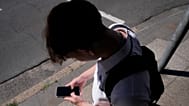 A teenage boy uses his phone in Sydney, Australia, on Nov. 8, 2024. 