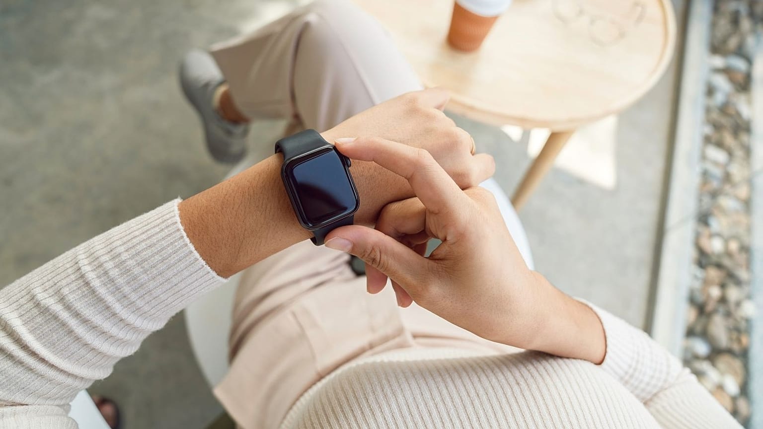 A woman adjusts her smartwatch.