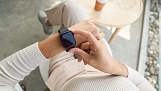 A woman adjusts her smartwatch.