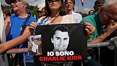 Uma mulher segura uma fotografia de Charlie Kirk onde se lê: "Eu sou Charlie Kirk", durante a reunião anual do partido da Liga em Pontida, no norte de Itália, no domingo, 21 de setembro de 2025.