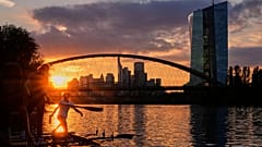 Die Sonne geht hinter der Europäischen Zentralbank (rechts) in Frankfurt, Deutschland, unter. 10. September 2025.