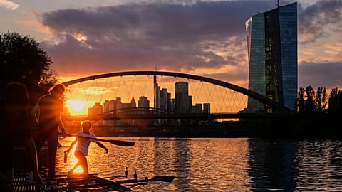 The sun sets behind the European Central Bank, right, in Frankfurt, Germany. 10 Sept. 2025.