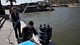 Senior technician Omar Bach-Rais tests water samples from the Seine river for analysis as Aurelie Lemaire, a microbiology research intern looks on, in Paris.