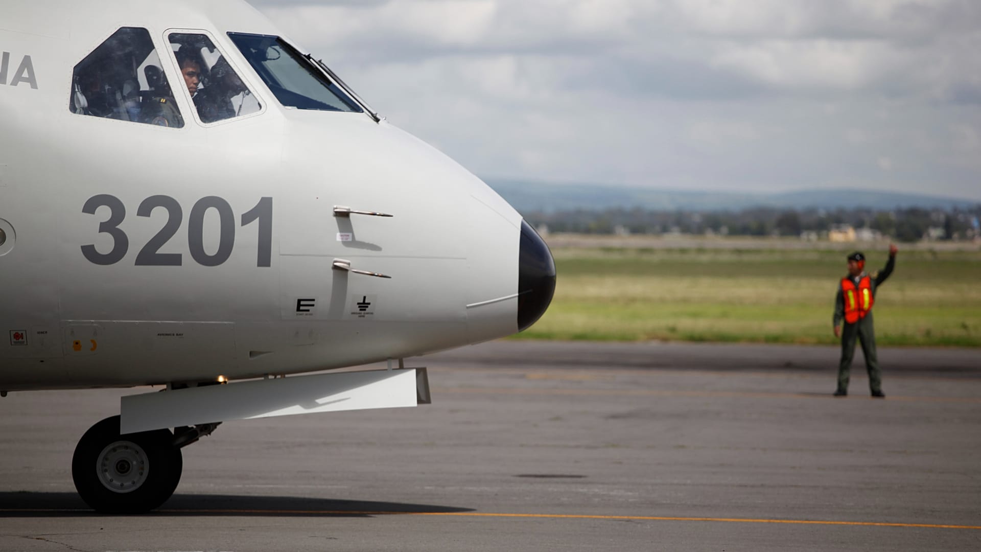 DOSSIER : Un militaire, à droite, donne des instructions au pilote d'un avion de transport, fabriqué en Espagne, à Santa Lucia, au Mexique, le 16 août 2010.