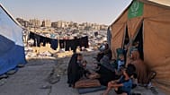 عائلة تجلس أمام خيمتها في مخيم للنازحين الفلسطينيين في المواصي، وهي المنطقة التي حددتها إسرائيل كمنطقة آمنة، في خان يونس، 23 أيلول 2025