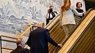 President Donald Trump, center, and First Lady Melania Trump, upper right, walk up the escalator