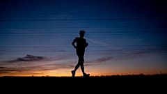 Un hombre corre por una pequeña carretera en las afueras de Fráncfort, Alemania, antes del amanecer del 8 de septiembre de 2020.