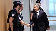 Former French President Nicolas Sarkozy shakes hands with a police officer before his verdict in Paris, 25 September 2025