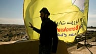 صورة تعبيرية لمقاتل من قوات سوريا الديمقراطية  المدعومة من الولايات المتحدة، على سطح مبنى يطل على الباغوز في سوريا