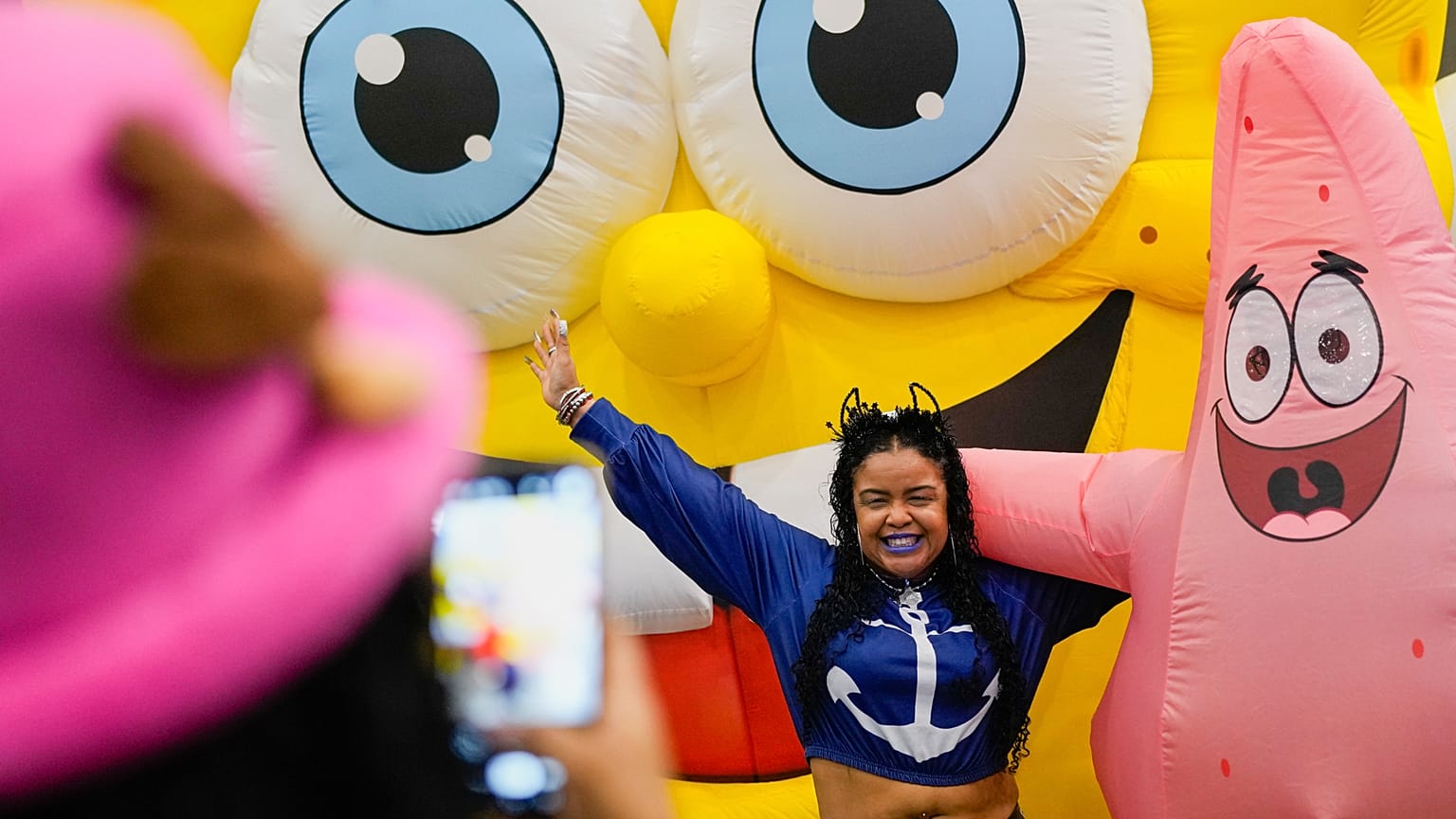 Una mujer posa para una foto con los personajes de Bob Esponja durante una conferencia de prensa del Comic-Con de Panamá
