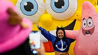 Una mujer posa para una foto con los personajes de Bob Esponja durante una conferencia de prensa del Comic-Con de Panamá