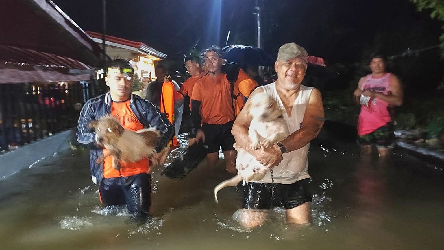 Residents and their dogs are evacuated by rescuers as floods rise due to Typhoon Bualoi