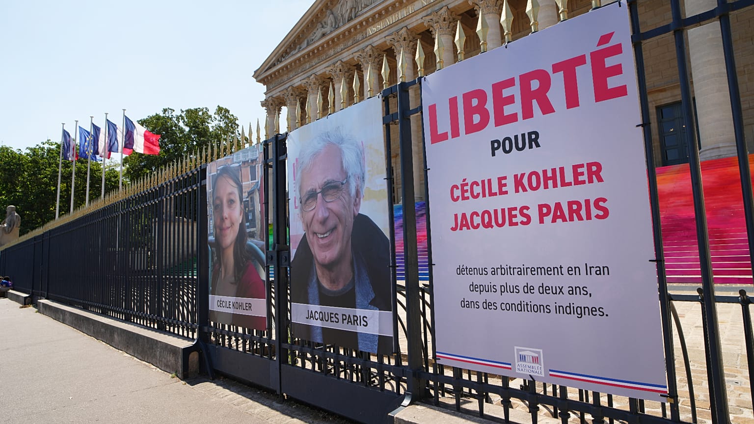 Les portraits des ressortissants français Cécile Kohler, à gauche, et Jacques Paris, emprisonnés depuis plus de trois ans en Iran, devant l'Assemblée nationale.