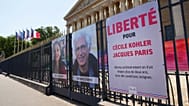 Les portraits des ressortissants français Cécile Kohler, à gauche, et Jacques Paris, emprisonnés depuis plus de trois ans en Iran, devant l'Assemblée nationale.