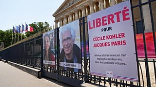Les portraits des ressortissants français Cécile Kohler, à gauche, et Jacques Paris, emprisonnés depuis plus de trois ans en Iran, devant l'Assemblée nationale.