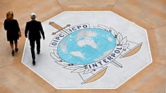 Άνθρωποι περπατούν πάνω στο λογότυπο της Ιντερπόλ στην έδρα της διεθνούς αστυνομικής υπηρεσίας στη Λυών, 8 Νοεμβρίου 2018