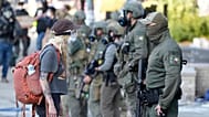 FILE - A woman stands off with a law enforcement officer wearing a Houston Field Office Special Response Team patch outside the U.S. Immigration and Customs (ICE) building dur