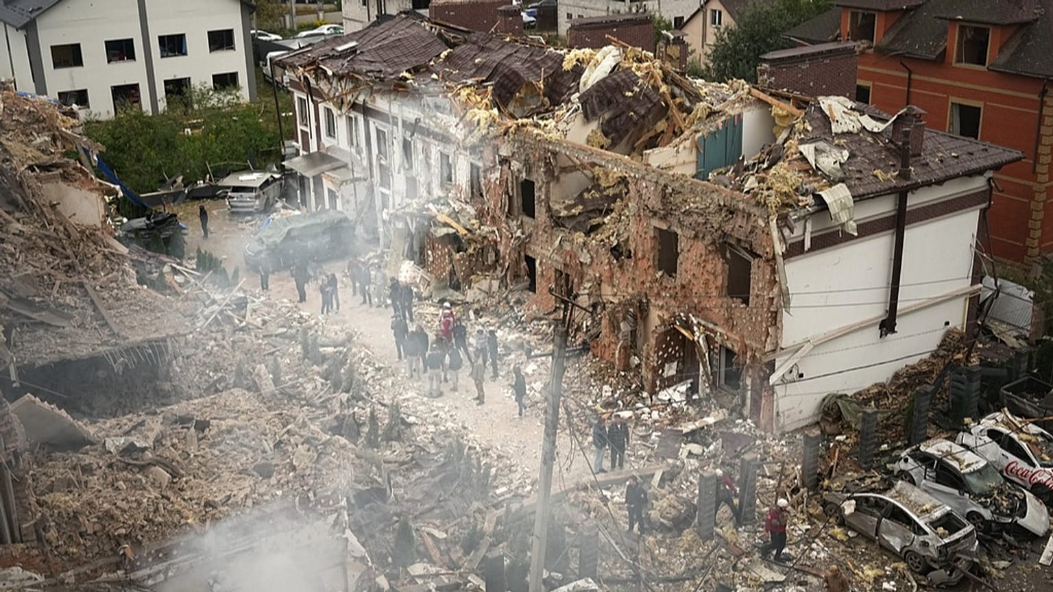 Persone osservano il sito di un edificio distrutto durante un attacco russo a Kiev, in Ucraina, domenica 28 settembre 2025.