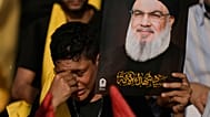 مناصر لحزب الله يبكي وهو يحمل صورة لقائد الحزب السيد حسن نصر الله، الذي قُتل في غارات جوية إسرائيلية، خلال مراسم عند قبر نصر الله في بيروت، لبنان