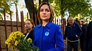 Moldova's President Maia Sandu holds a bouquet of flowers as she leaves a voting station after casting her vote during a parliamentary election, in Chisinau, Moldova, Sept. 28