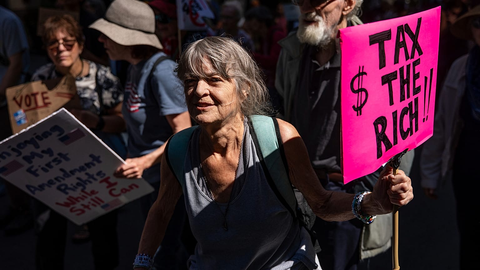 Una mujer con un cartel que dice "Impuestos a los ricos" marcha por Manhattan, el sábado 20 de septiembre de 2025, en Nueva York.