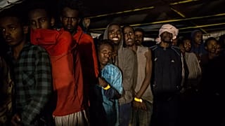 En esta fotografía del viernes 21 de diciembre de 2018, migrantes permanecen en la cubierta del barco de rescate de la ONG española Proactiva Open Arms.