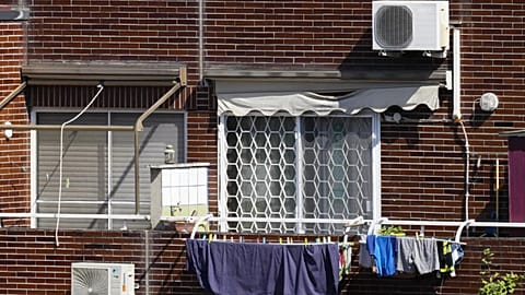Air conditioning units are seen on the facade of a building in Rome, Tuesday, July 25, 2023. 
