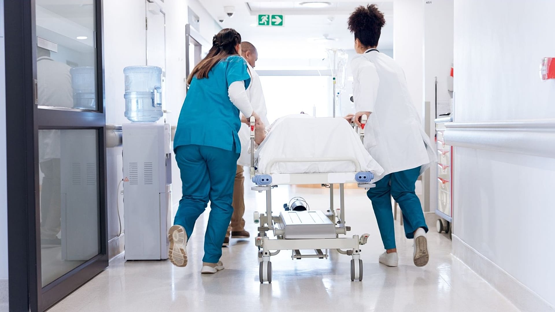 Pracownicy służby zdrowia pędzą przez szpitalny korytarz.