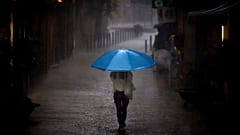 Une femme marche sous une forte pluie à Barcelone, le 11/09/2025