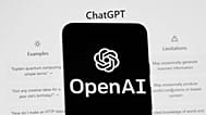 FILE - The OpenAI logo is seen on a mobile phone in front of a computer screen which displays the ChatGPT home Screen, on March 17, 2023, in Boston.