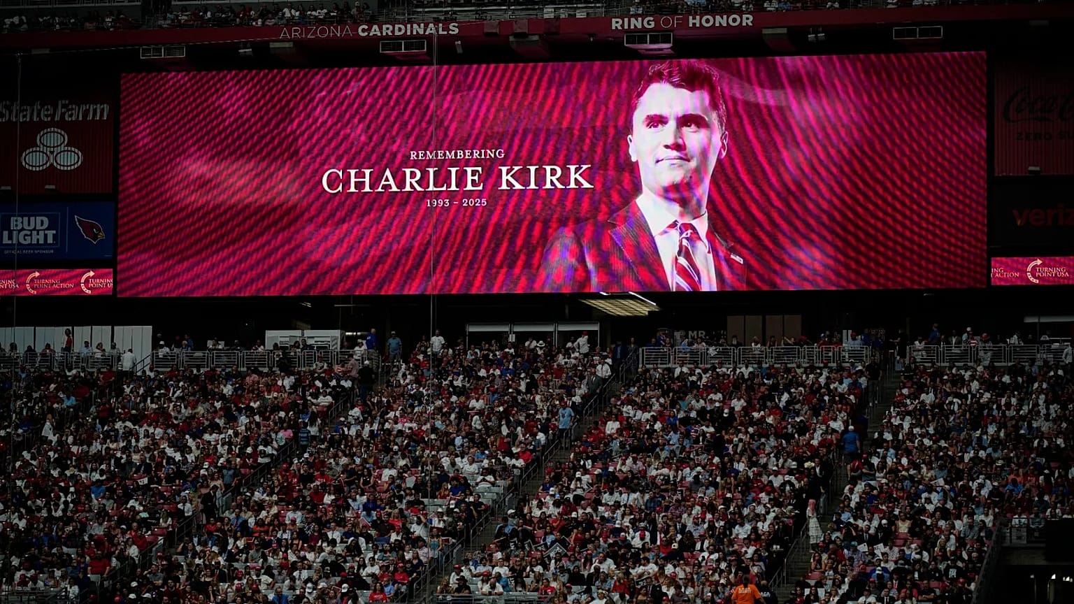 A photo of the conservative activist Charlie Kirk is seen on a large screen during a memorial in Glendale, 21 September, 2025