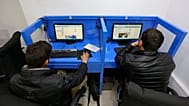 Kabil'de bir internet kafede iki kişi sosyal medyada yayınlanmış gönderilere bakarken, 12 Şubat 2016