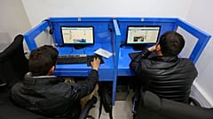 Kabil'de bir internet kafede iki kişi sosyal medyada yayınlanmış gönderilere bakarken, 12 Şubat 2016