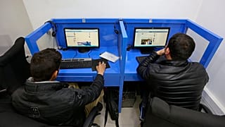 Kabil'de bir internet kafede iki kişi sosyal medyada yayınlanmış gönderilere bakarken, 12 Şubat 2016