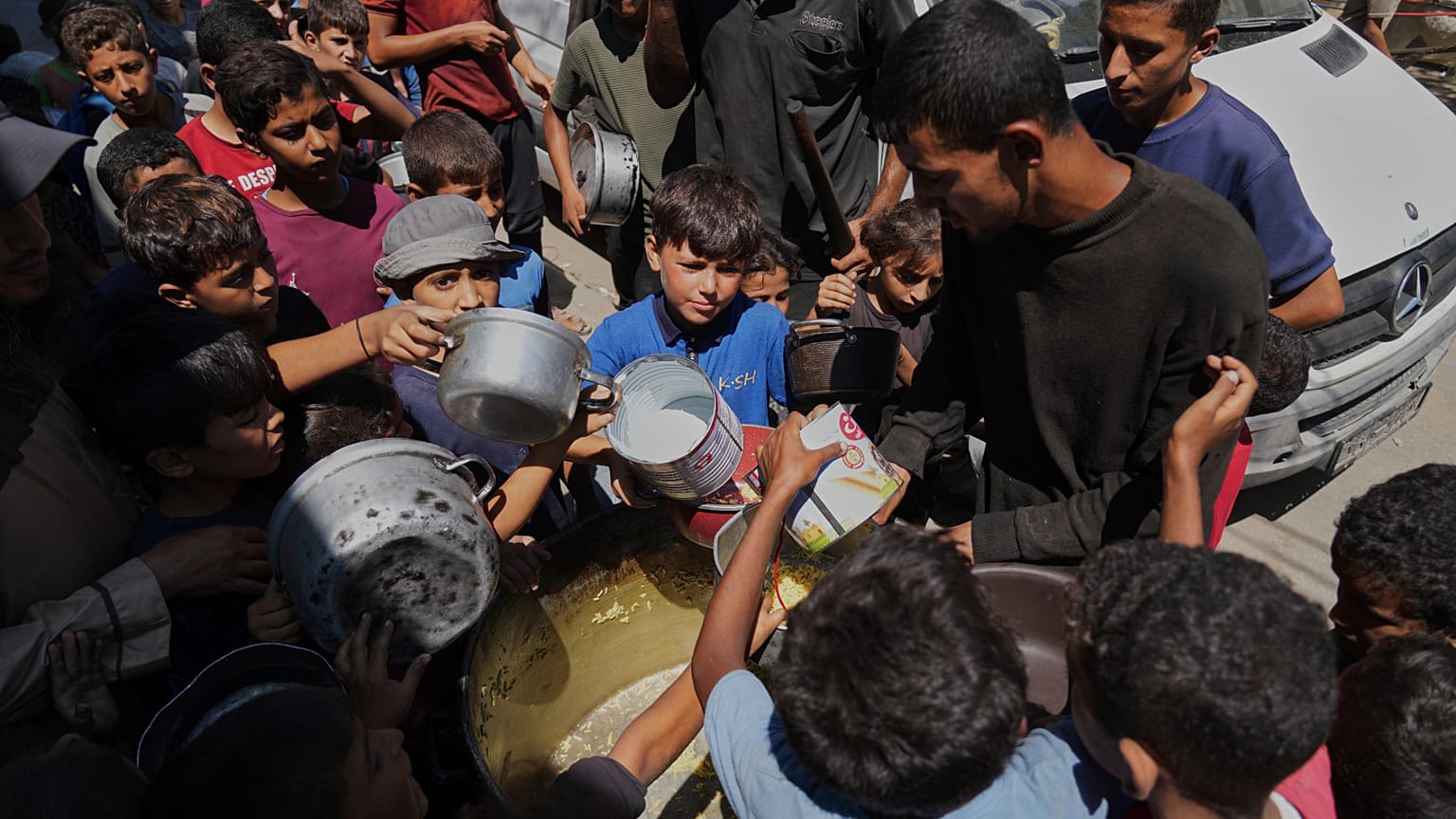 Bambini palestinesi ricevono cibo in una mensa comunitaria a Deir al-Balah, nella Striscia di Gaza centrale (12 settembre 2025)
