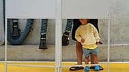 Uma criança observa um eleitor preencher o seu boletim de voto nas eleições gerais de Portugal, numa assembleia de voto em Lisboa, no domingo, 18 de maio de 2025. 