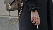 FILE: A woman holds a cigarette during a break in Paris, 28 May 2025