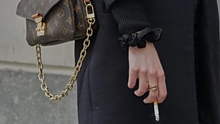 FILE: A woman holds a cigarette during a break in Paris, 28 May 2025