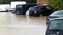 Fahrzeuge, die bei Überschwemmungen auf einem Parkplatz im Freien unter Wasser stehen